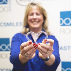 woman holding aligners